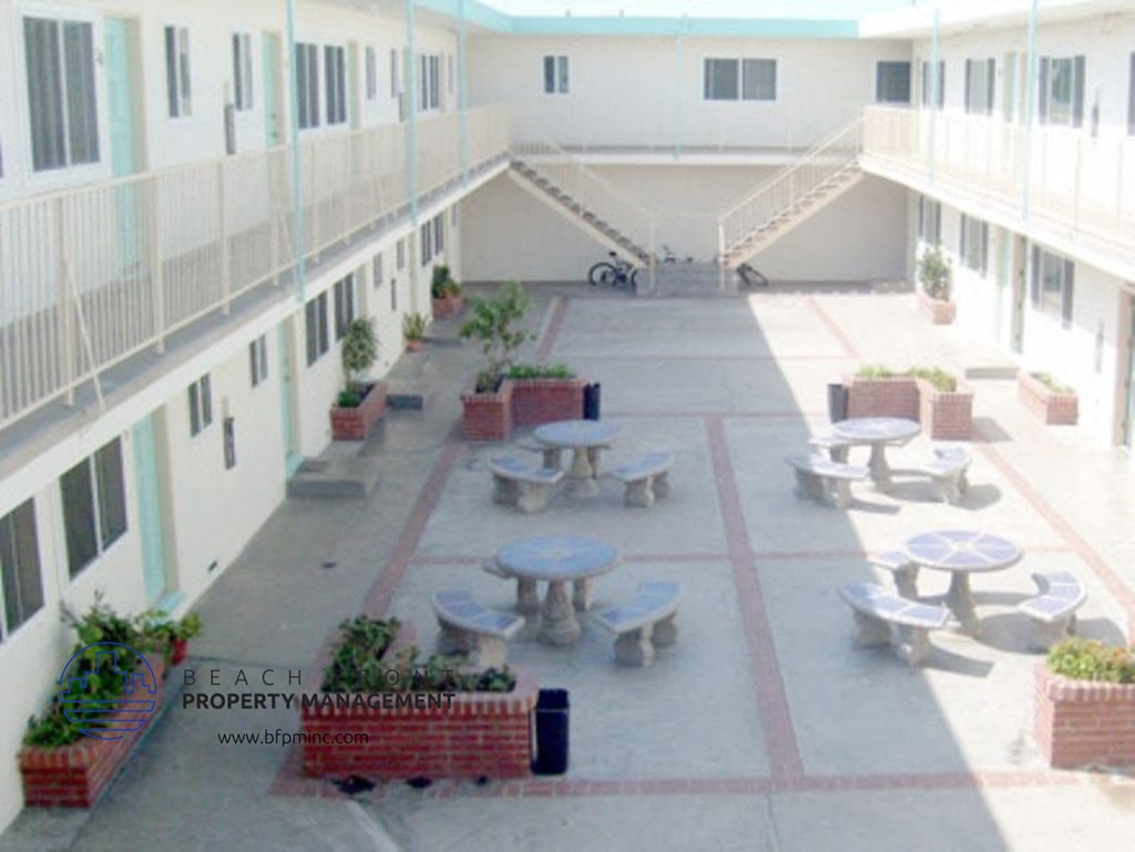 a courtyard with tables and benches in an apartment building
