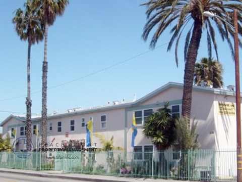 A building with palm trees in front of it.