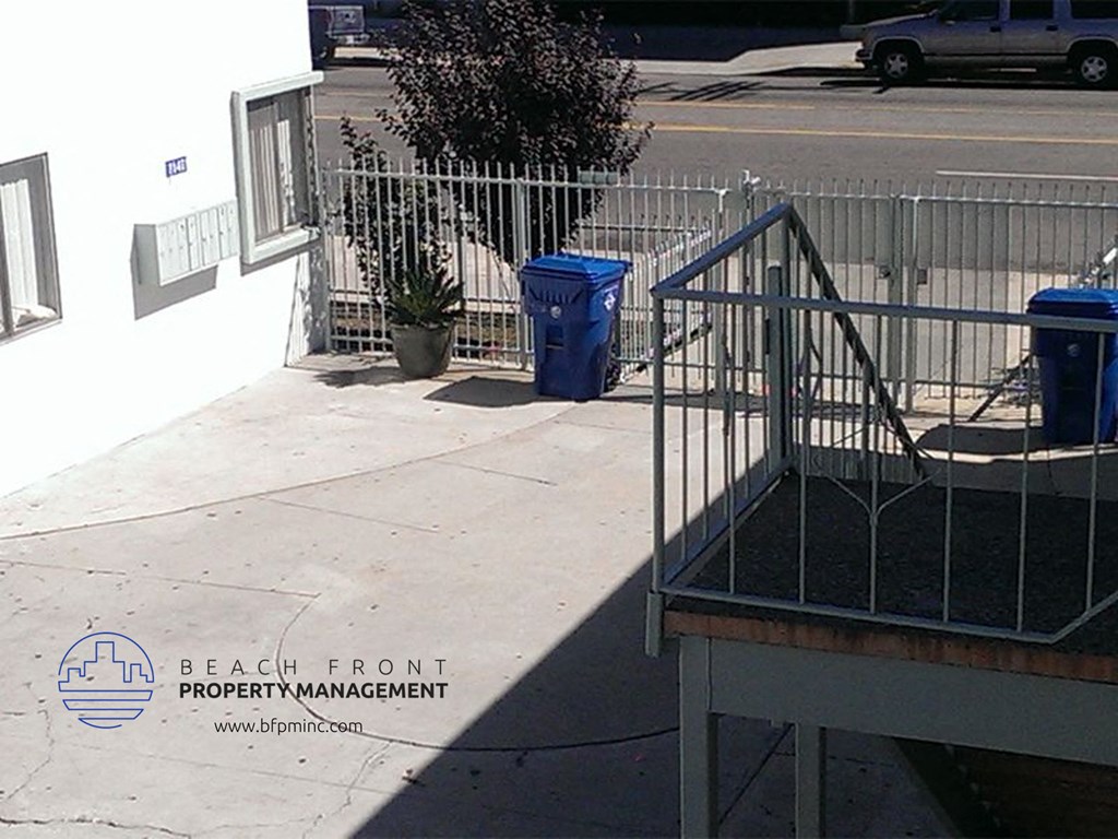 a metal railing on a sidewalk next to a building