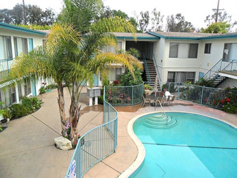 an aerial view of a pool in front of a house