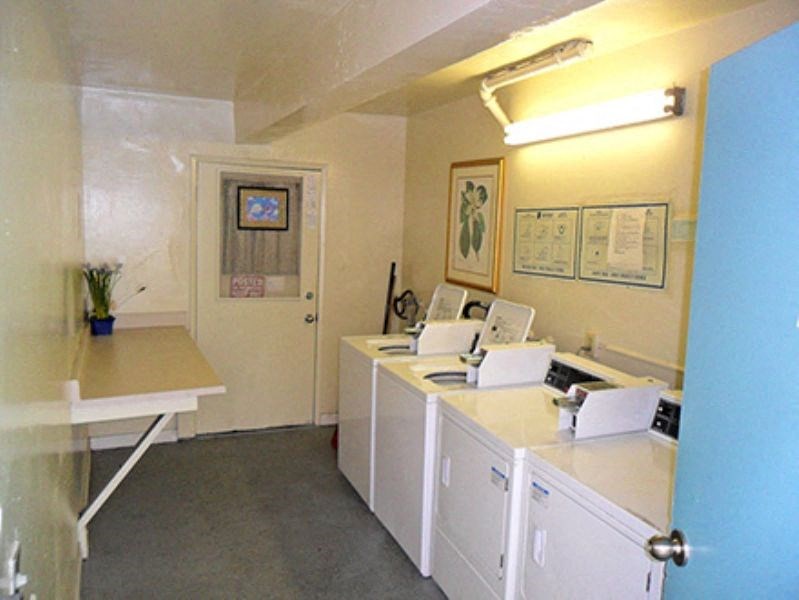 a laundry room with white appliances and a counter