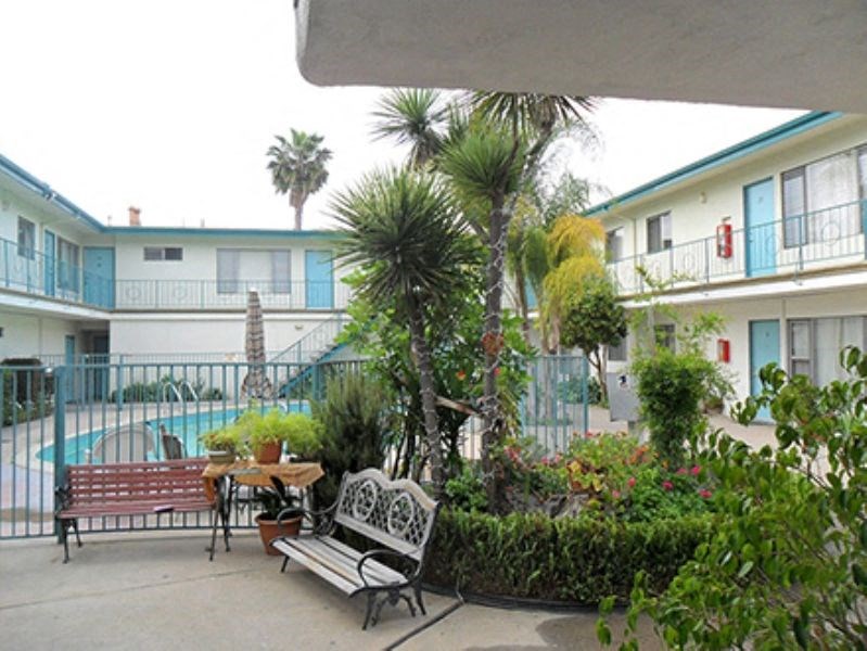 a patio with benches and a table in front of a building