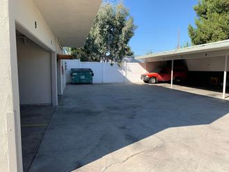 a parking garage with a white wall and a red car in it