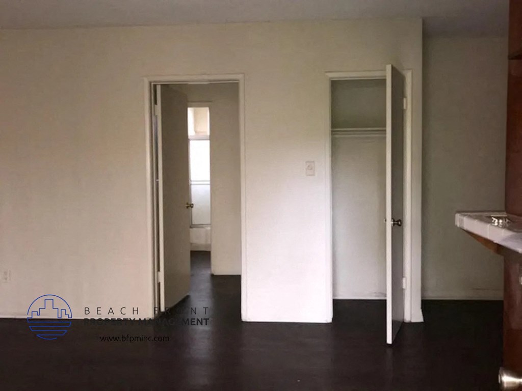 an empty room with two doors and a sink