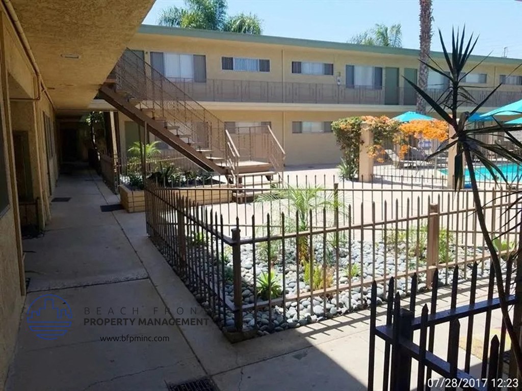the courtyard of a building with a fence and a pool
