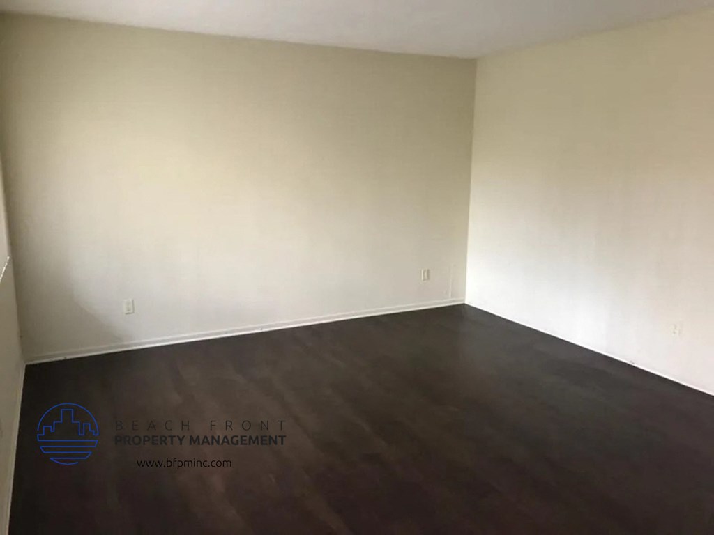 an empty living room with white walls and wooden floors