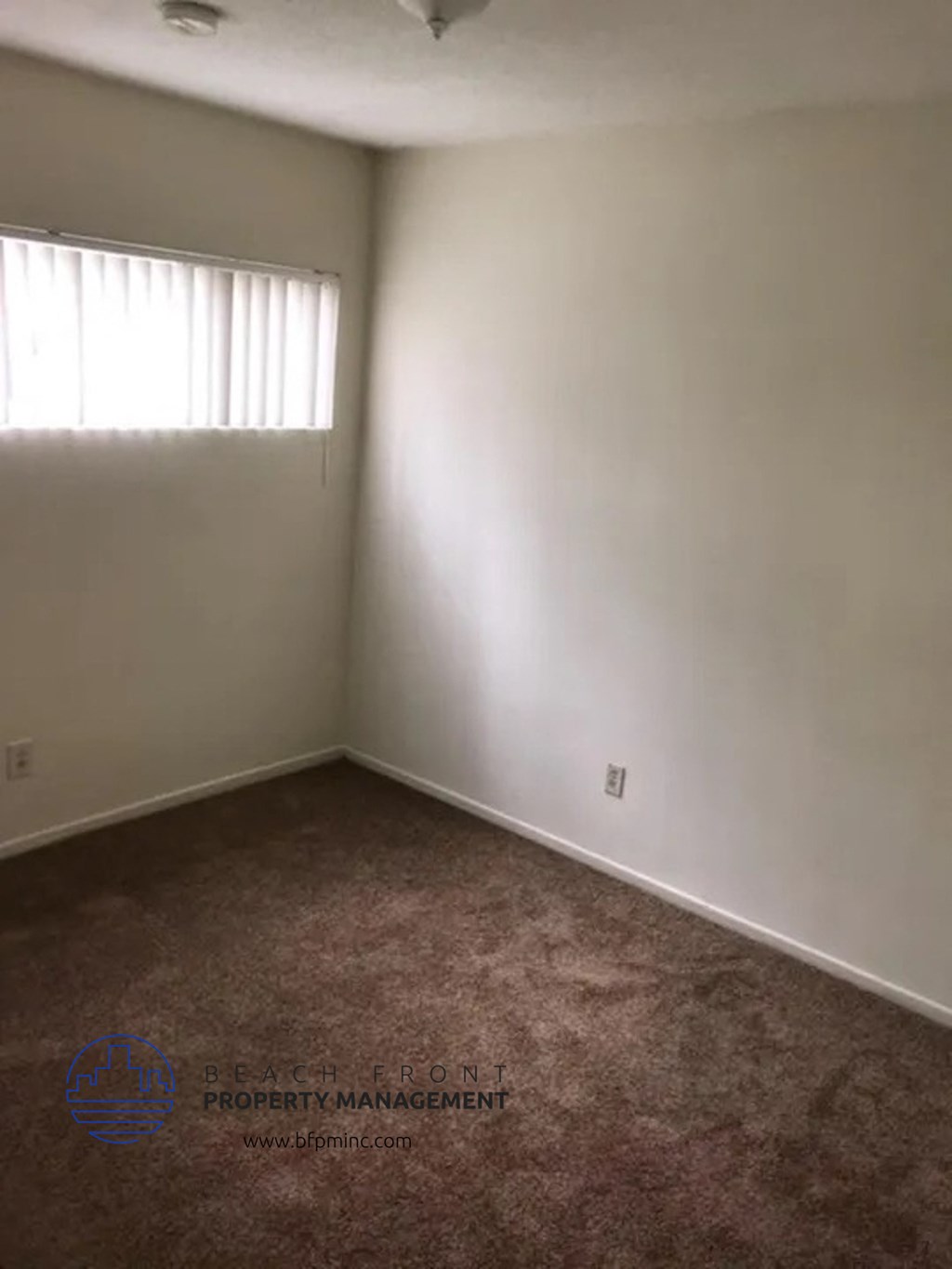 an empty room with white walls and a window