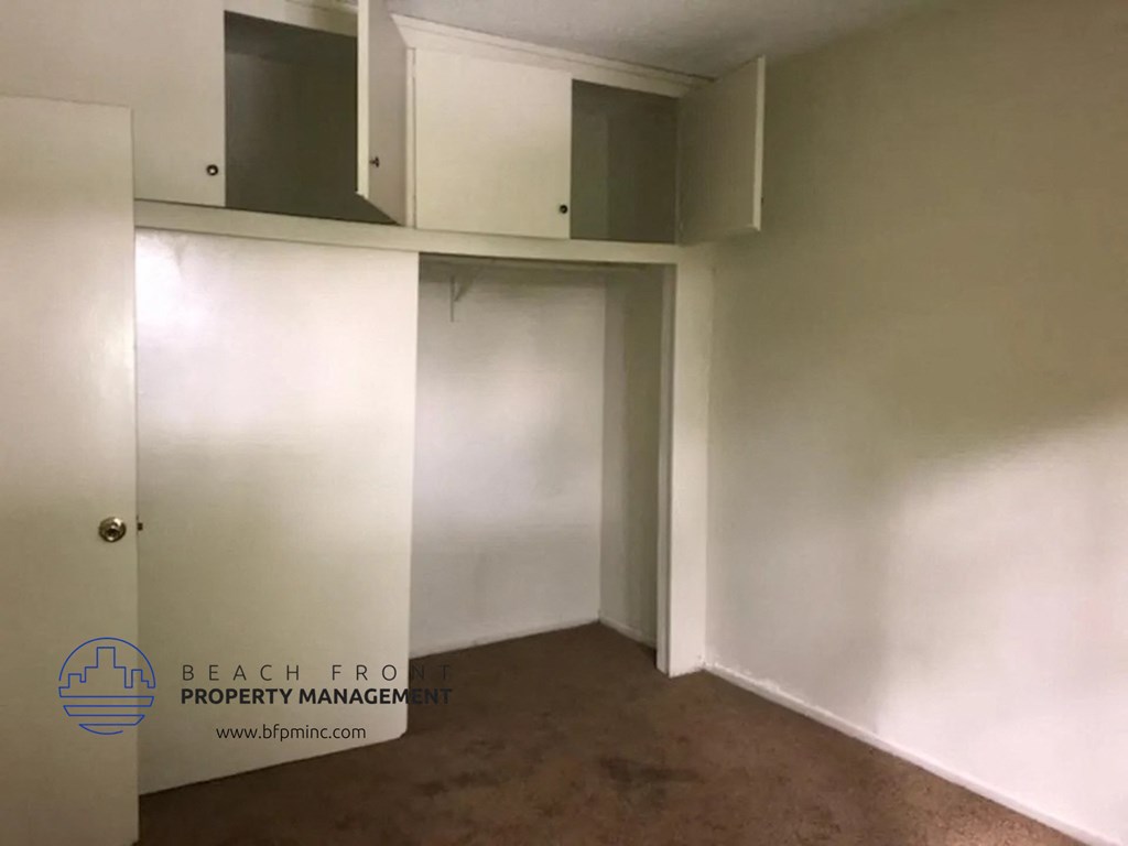 an empty room with white walls and a closet and a door