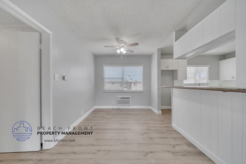 a kitchen with white cabinets and a ceiling fan