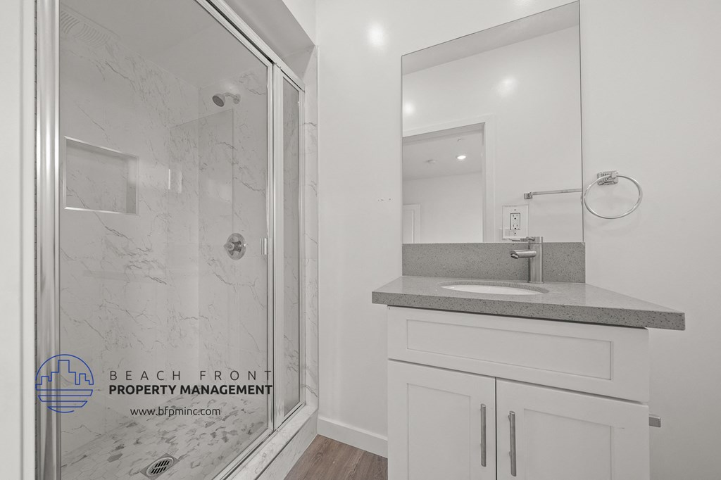 a bathroom with a shower and a sink and a mirror