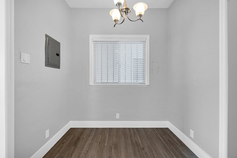 A room with a window and a chandelier.