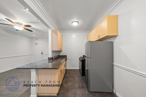 a kitchen with white walls and a stainless steel refrigerator