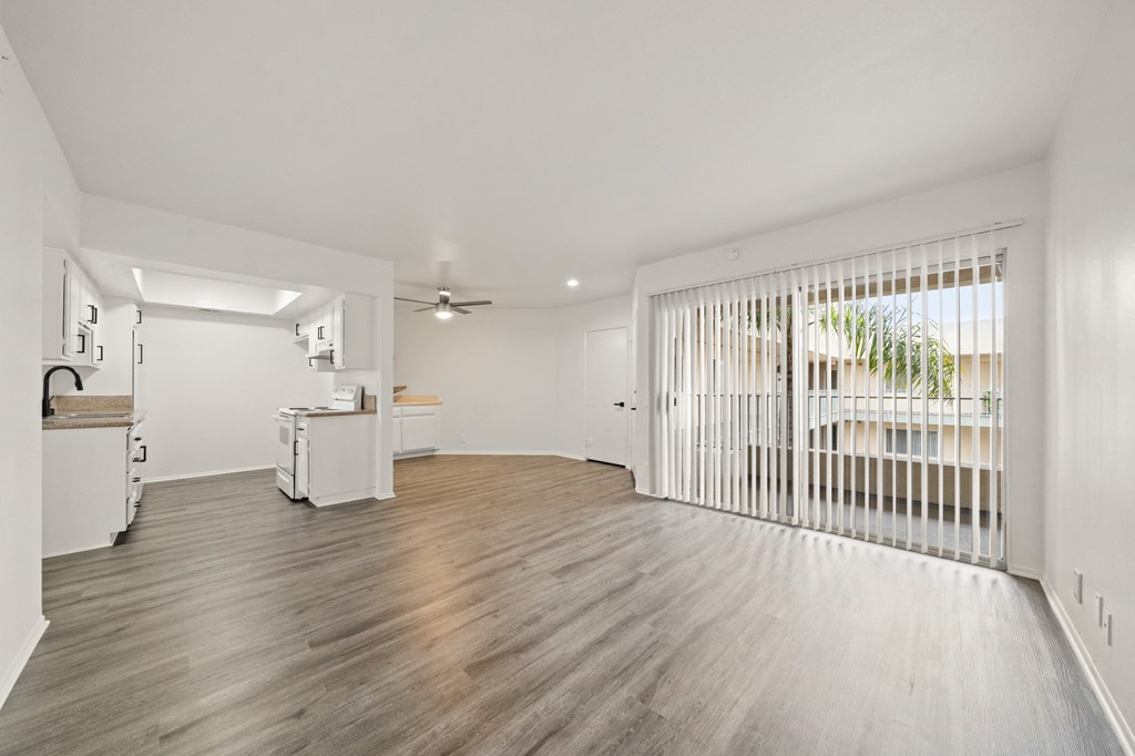 a living room with a sliding glass door and a kitchen