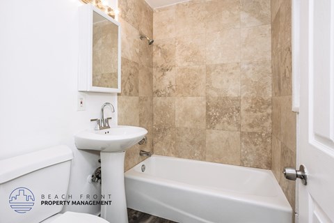 A bathroom with a white sink and bathtub.