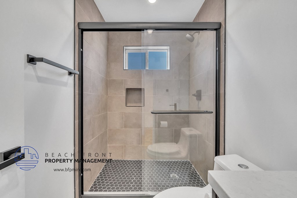 a bathroom with a shower and a toilet and a sink