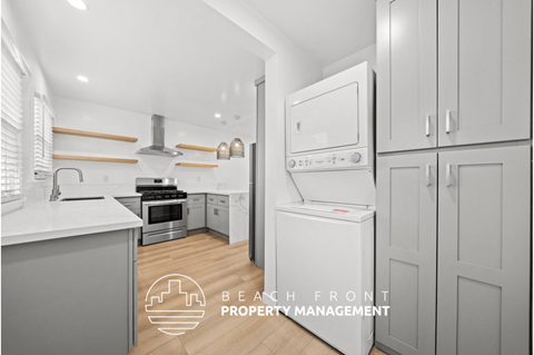 a white and gray kitchen with white appliances and white cabinets