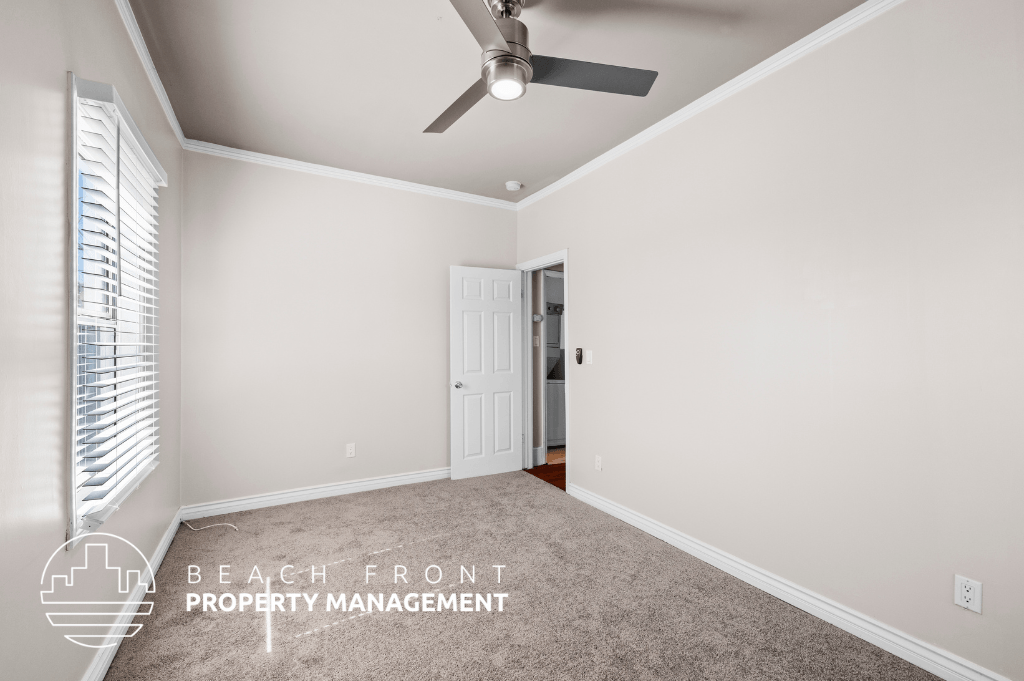 a living room with a ceiling fan and a carpet