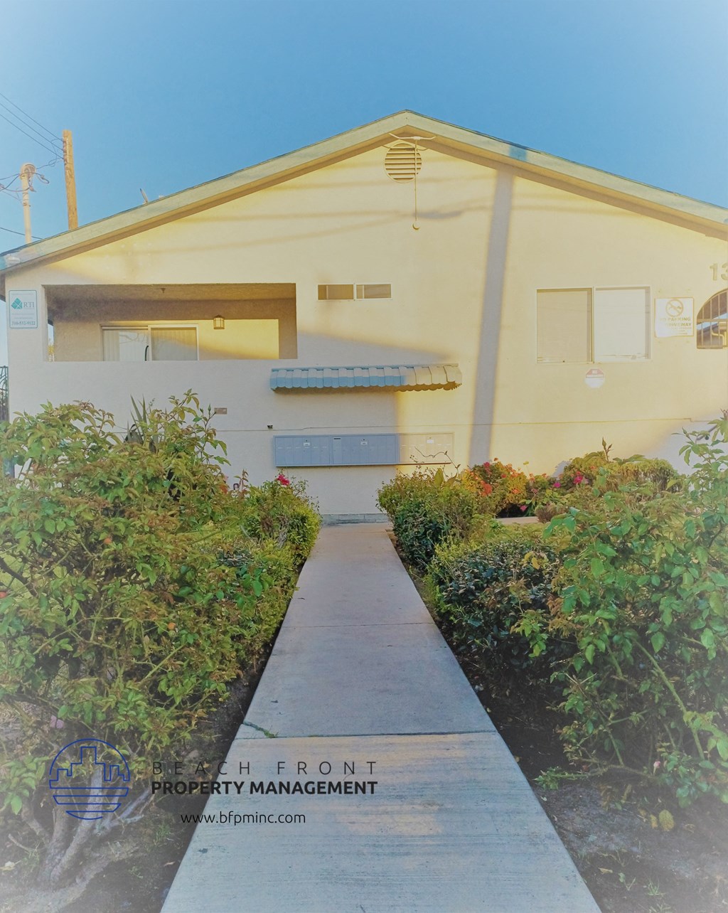 a white house with a sidewalk in front of it