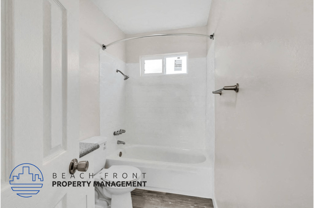 a white bathroom with a shower and a window