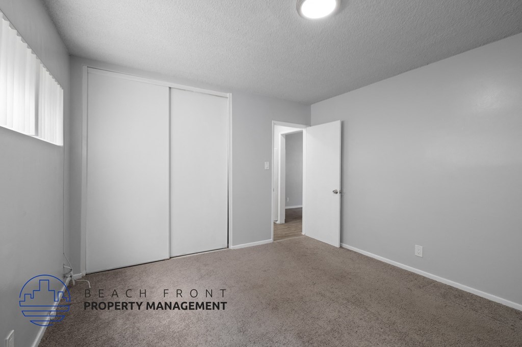 a master bedroom with white closets and a carpeted floor