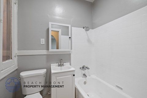 a white bathroom with a tub and a sink and a toilet