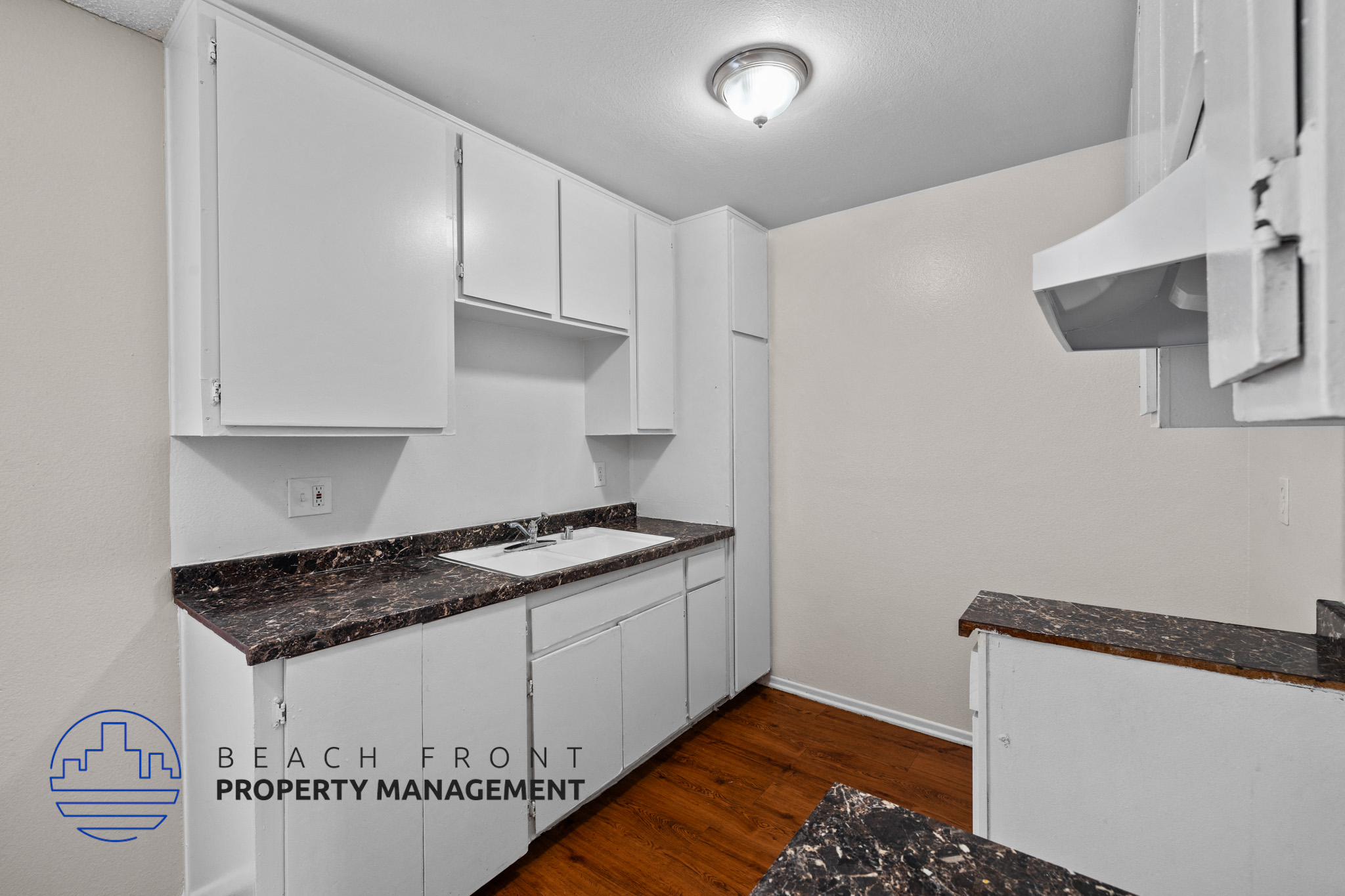 A kitchen with white cabinets and a granite countertop.