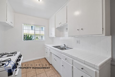 A kitchen with white cabinets and a tiled backsplash.