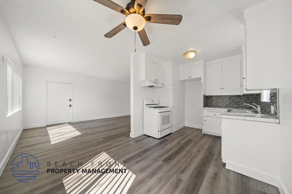 A kitchen with a fan and a logo for Beach Front Property Management.