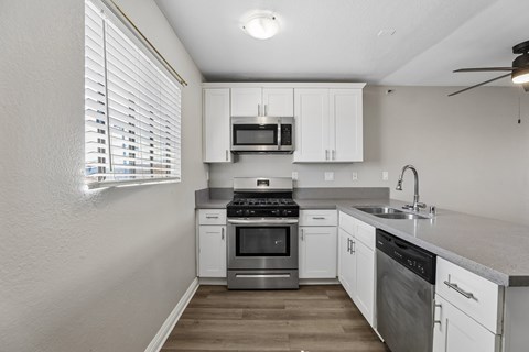 A kitchen with white cabinets and stainless steel appliances.