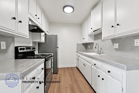 A kitchen with white cabinets and a black stove top oven.