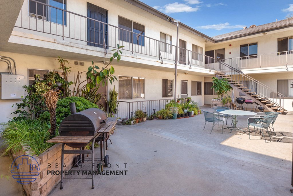 a patio with tables and chairs and a grill