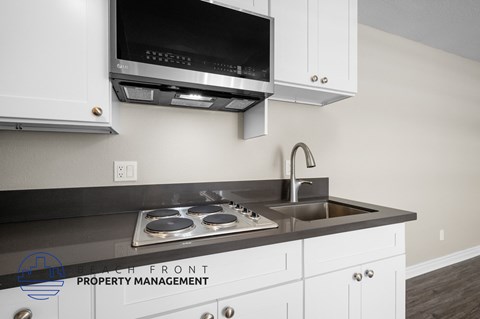 a kitchen with white cabinets and a sink and a microwave