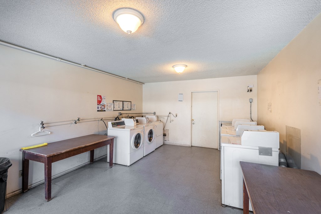 a laundry room with two washing machines and a table