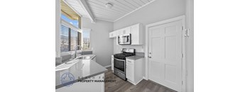 A kitchen with a sink, stove, and cabinets.
