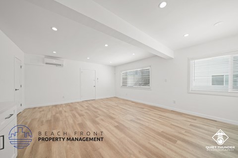 a living room with a hardwood floor and white walls and a white door
