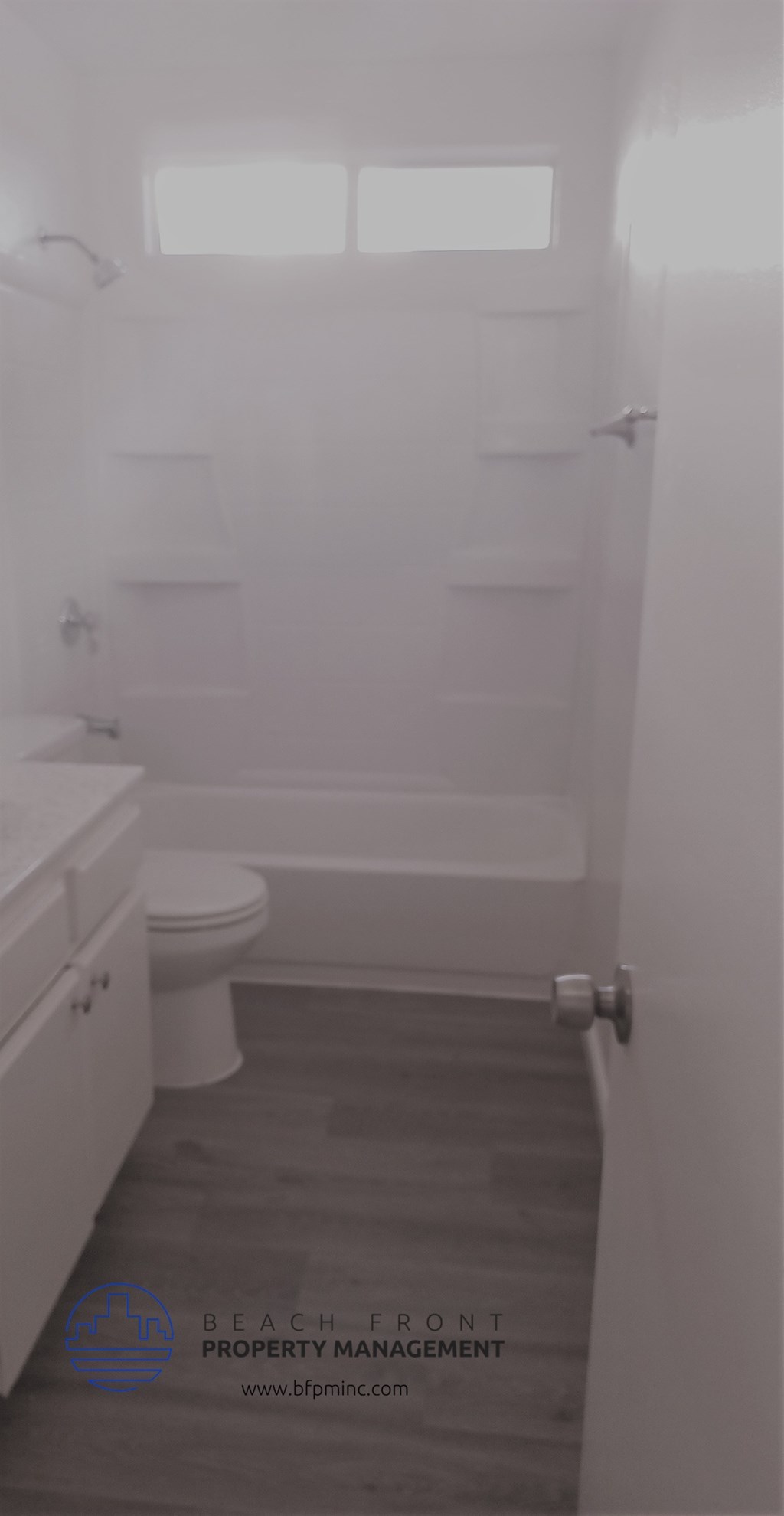 a white bathroom with a toilet and a bath tub