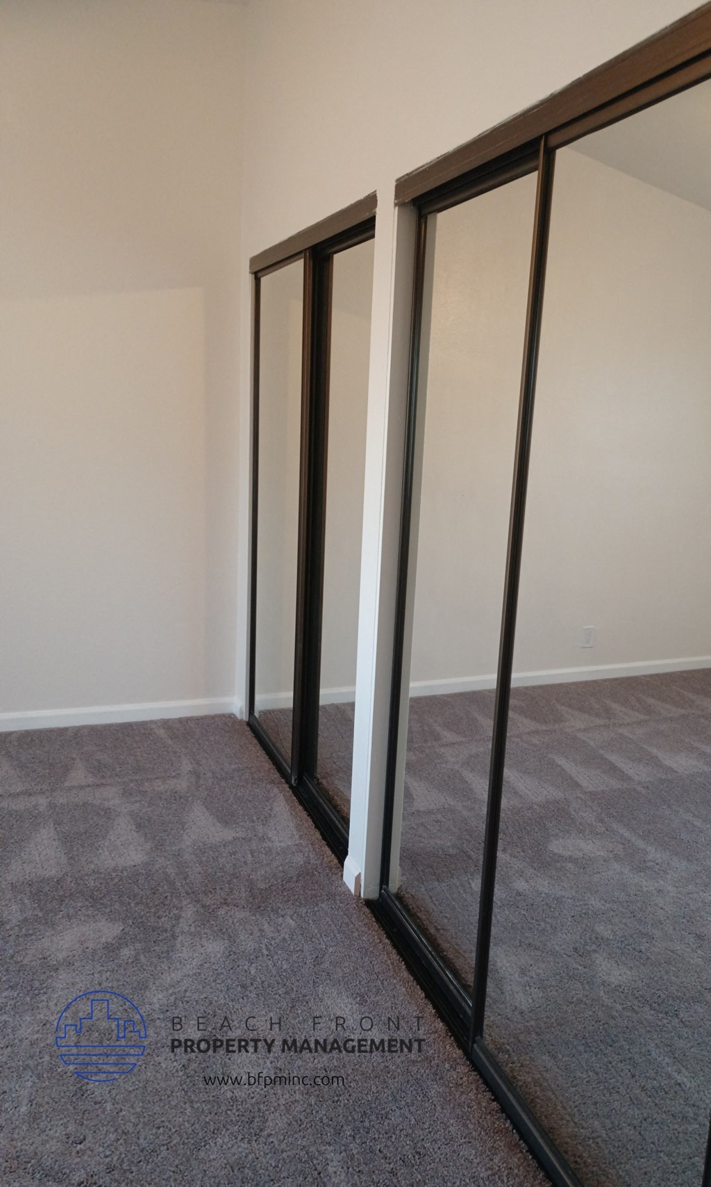 a room with three mirrors on the wall and a carpet