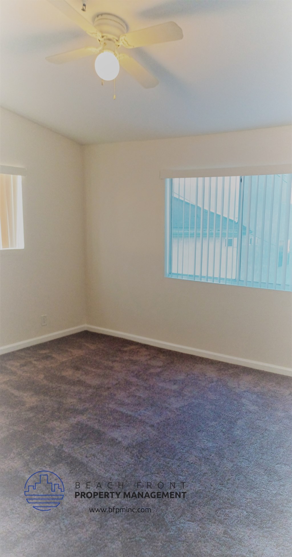 an empty room with a ceiling fan and a window