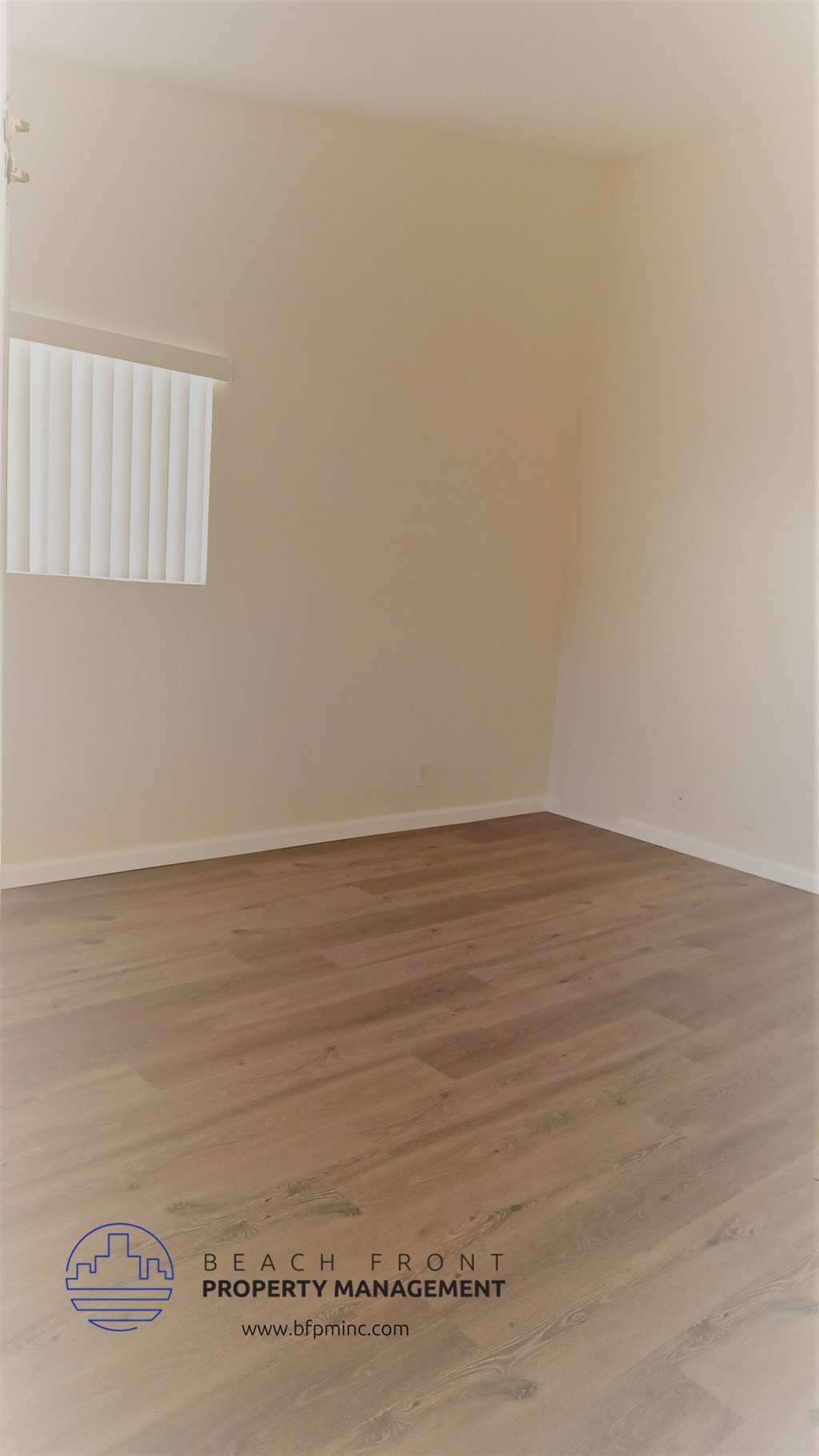an empty room with wooden floors and a window