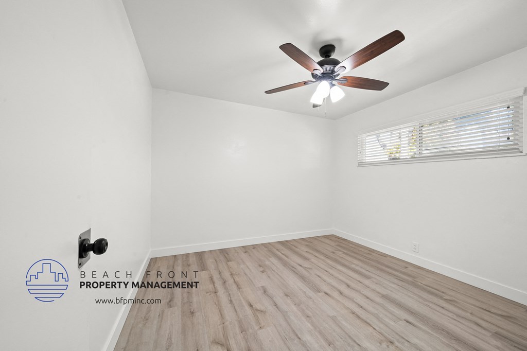 a bedroom with hardwood floors and a ceiling fan
