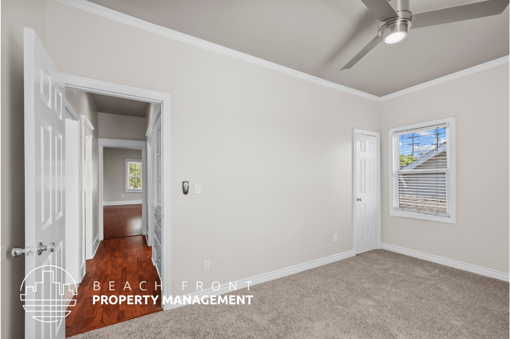 a bedroom with white walls and a hallway with a door and a window