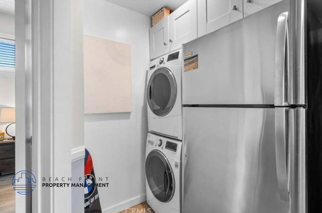 a stainless steel washer and dryer in a white kitchen