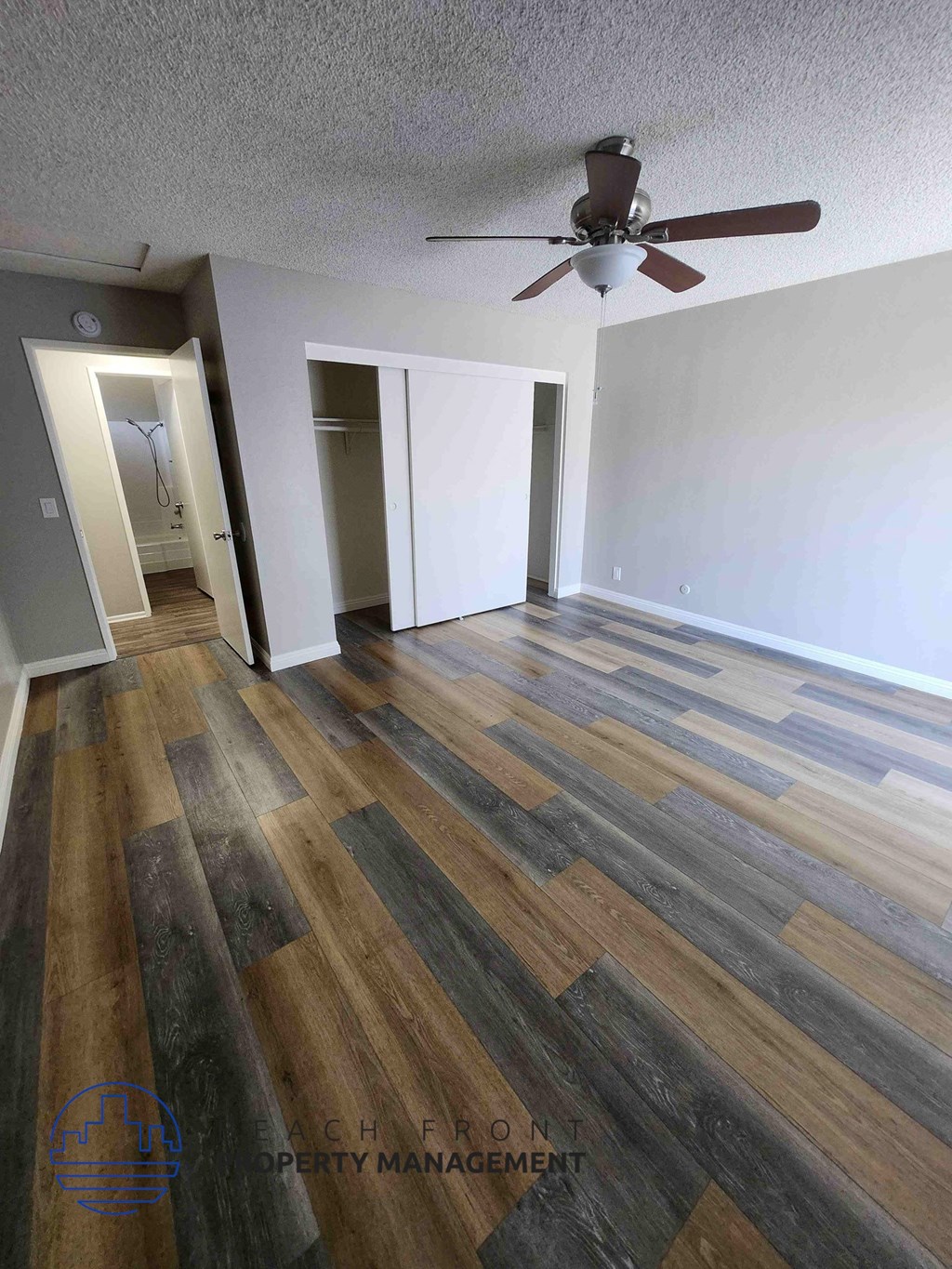 A room with a wooden floor and a ceiling fan.