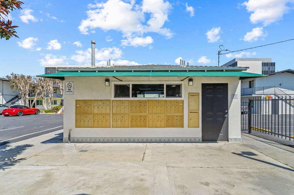a small building with a black door and a green roof