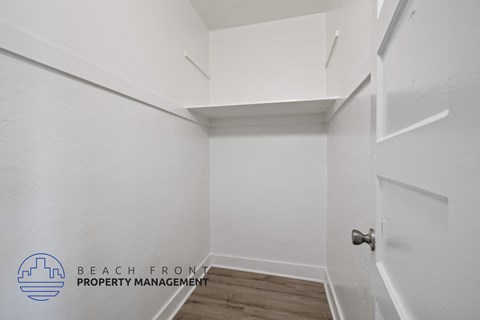 a walk in closet with white walls and a white door