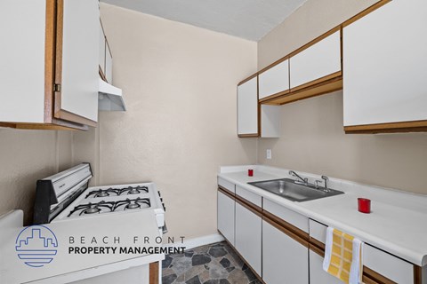 A kitchen with white cabinets and a stove top oven.