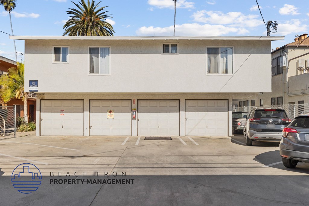 A white building with a sign that says Beach Front Property Management.
