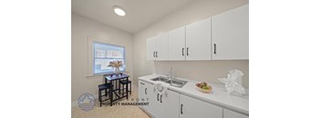 A kitchen with white cabinets and a sink.