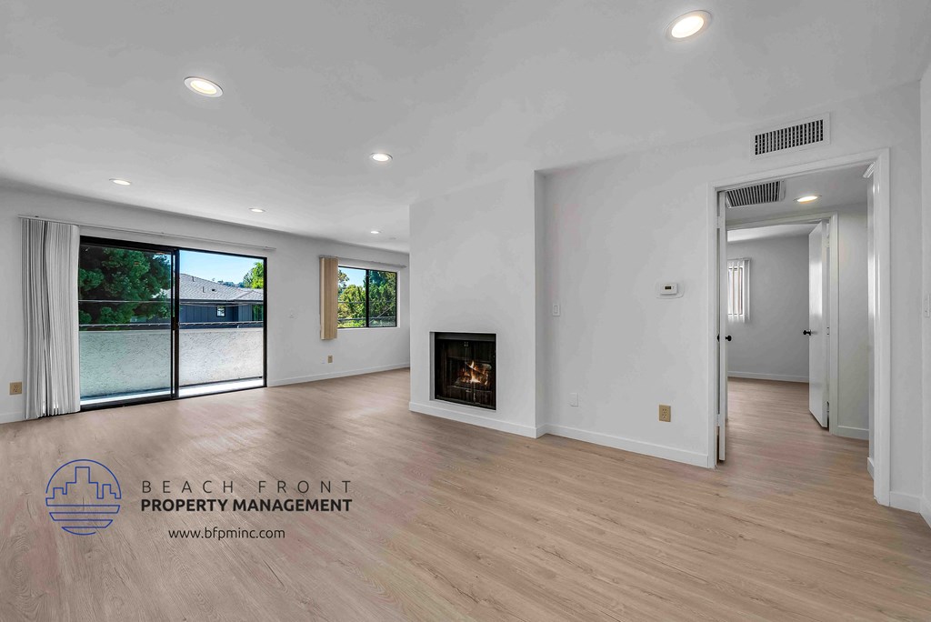 a large living room with hardwood floors and a fireplace