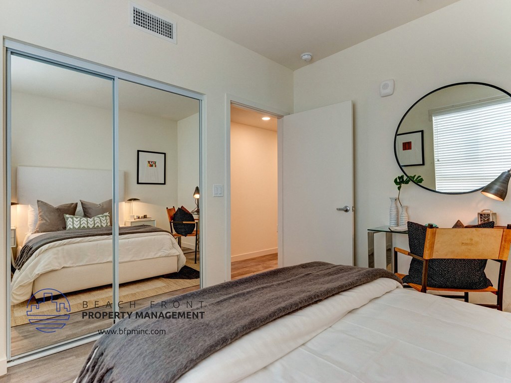 a bedroom with a large bed and a mirror